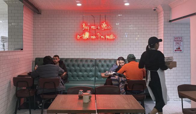 People eat inside the Siena Pizza restaurant in New York City on Dec. 9, 2021. (AP Photo/Ted Shaffrey, File)