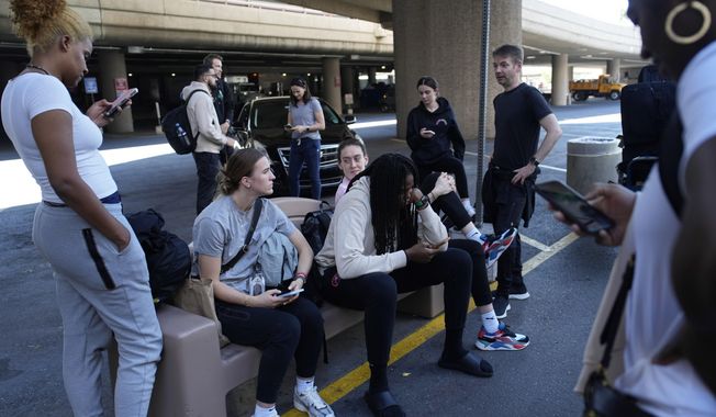 Players and staff of the New York Liberty WNBA basketball team wait to board buses at Harry Reid International Airport, Wednesday, June 28, 2023, in Las Vegas. The New York Liberty had a 13-hour travel day from Connecticut to Las Vegas during its recent three-game road trip, which required two bus rides, two commercial flights and a few hours in three airports. (AP Photo/John Locher)