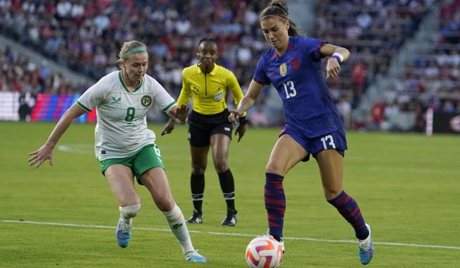 United States&#x27; Alex Morgan, right, and Ireland&#x27;s Ruesha Littlejohn battle for the ball during the first half of an international friendly soccer match Tuesday, April 11, 2023, in St. Louis. Overwhelming demand for tickets meant co-host Australia&#x27;s opening match against Ireland at the Women&#x27;s World Cup had to be shifted to the tournament&#x27;s biggest stadium and will be played in front of an expected record crowd of 82,500 on Thursday, July 20, 2023. (AP Photo/Jeff Roberson, File)